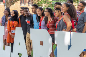students standing in front of clarku hashtag signage