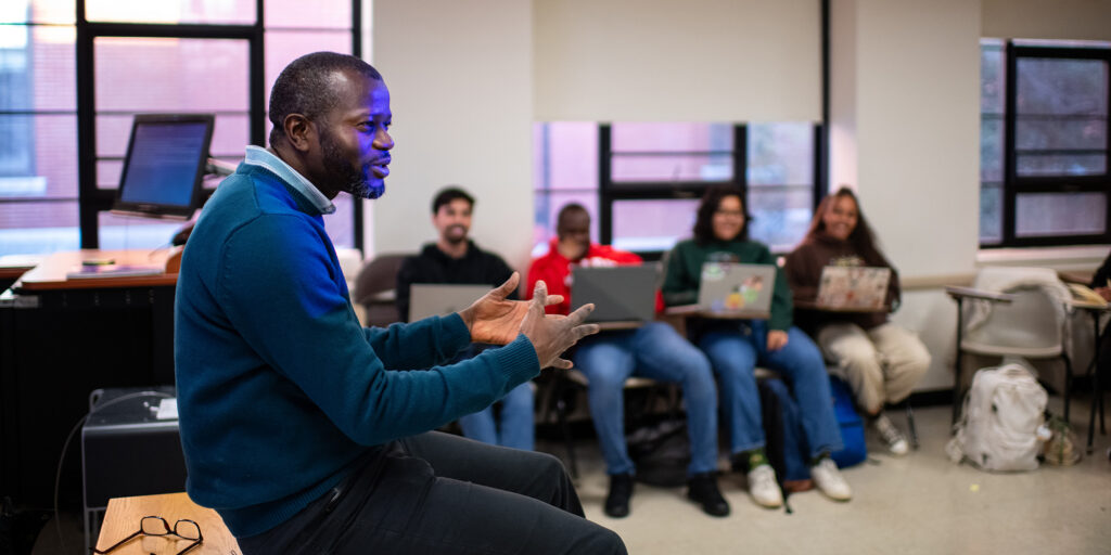 A Sustainability and Social Justice professor leads a group discussion in the classroom