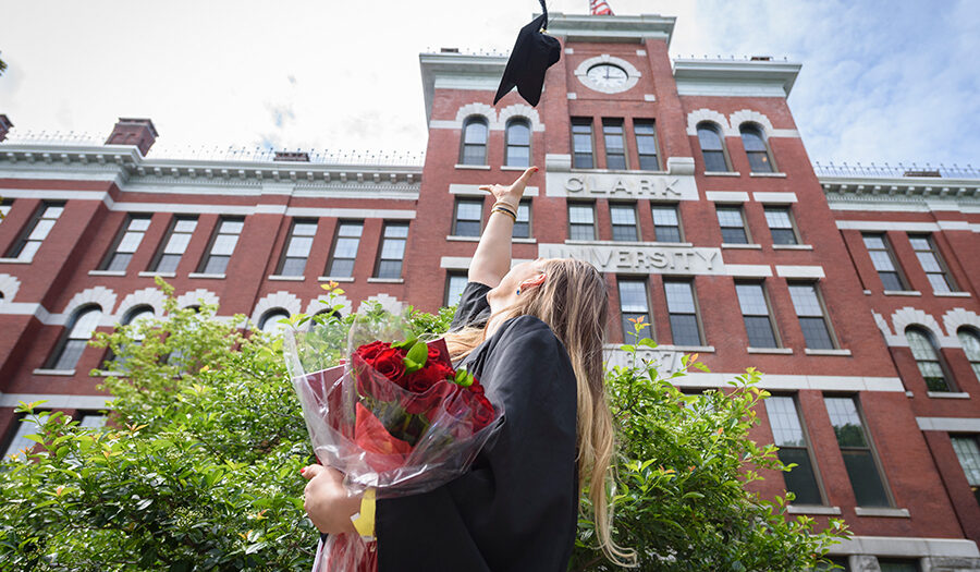 girl in graduation gown throwing up hat