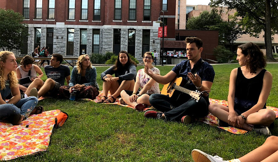 students sitting around in a circle on the gra