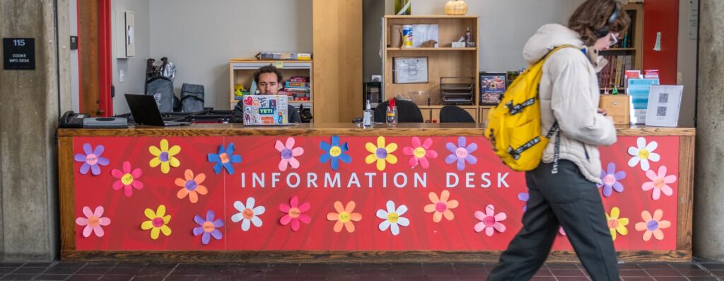 A student tends to the information desk