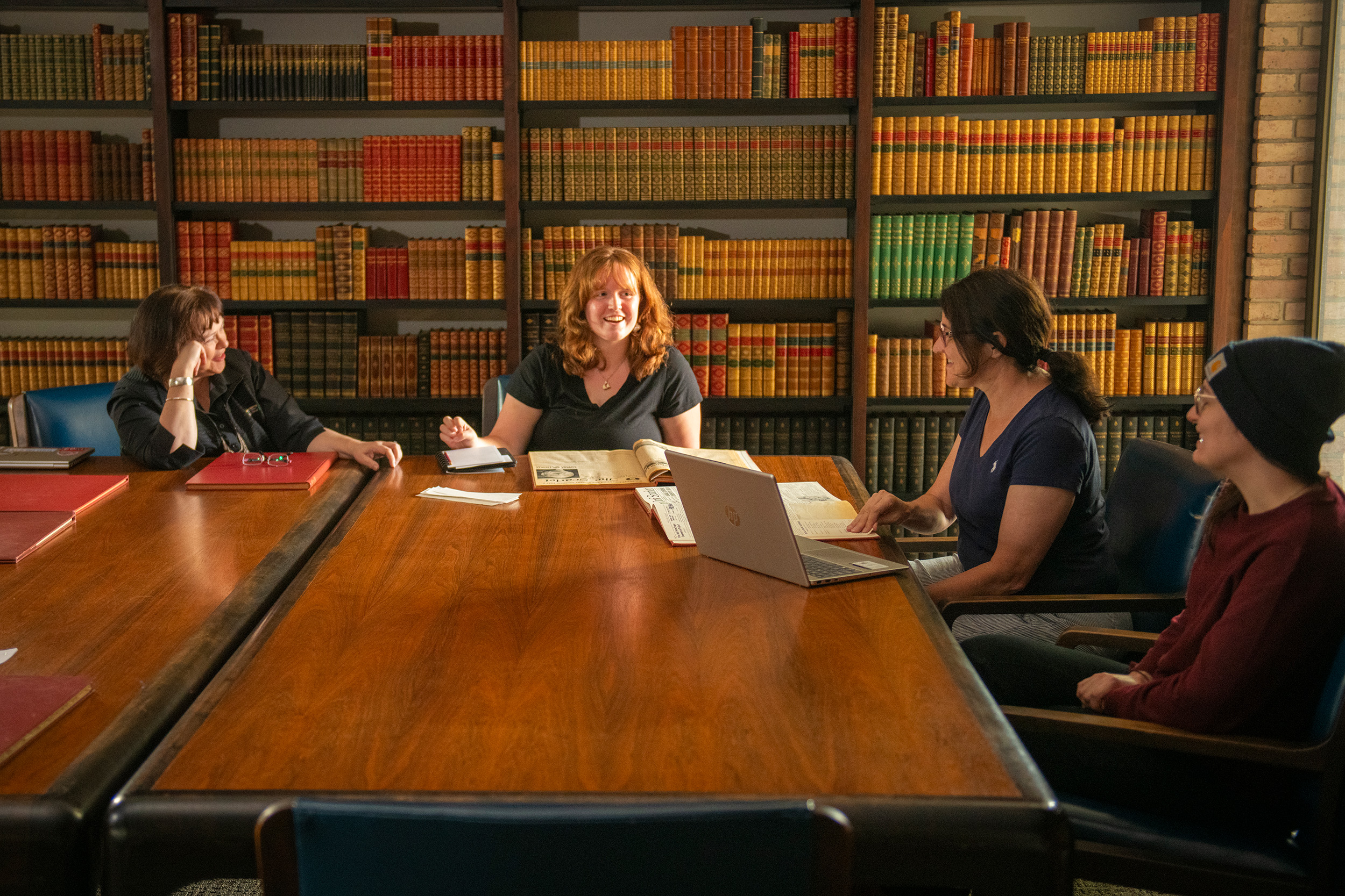 Group of women talking around a table in a library room