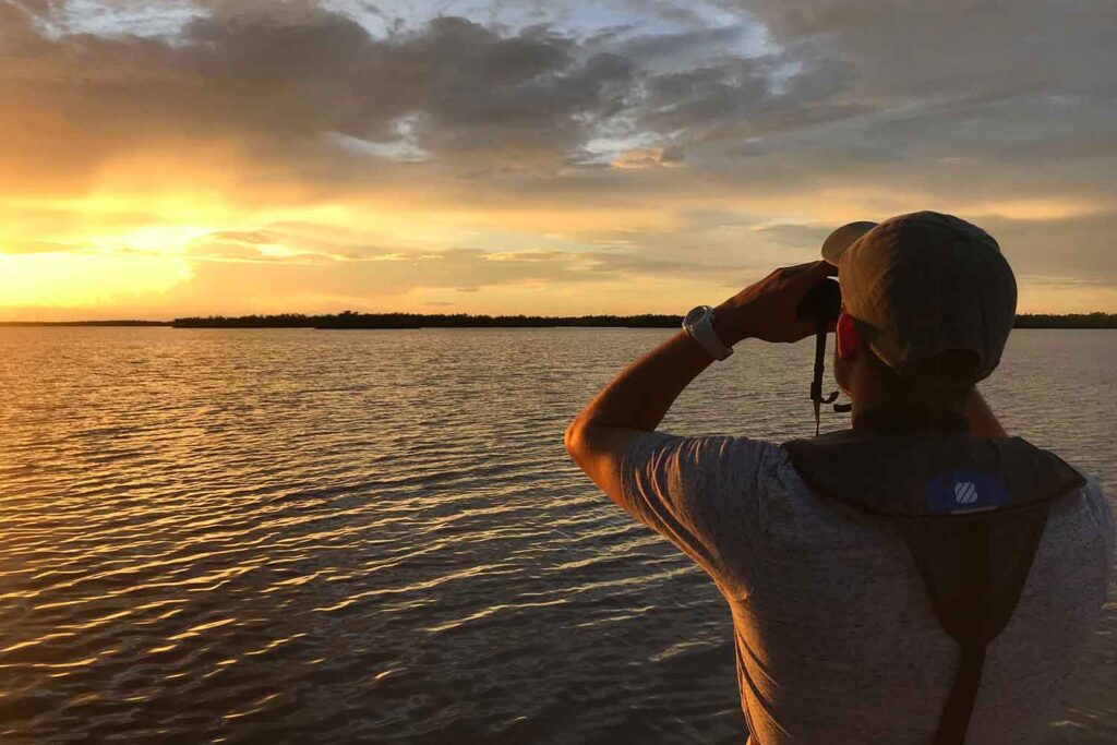 Anthony Himmelberger, an environmental science major, looks through a pair of binoculars at sunset, during his internship at the Rookery Bay National Estuarine Research Reserve in Naples, Fla., assessing loggerhead sea turtle nesting along the Cape Romano beaches.