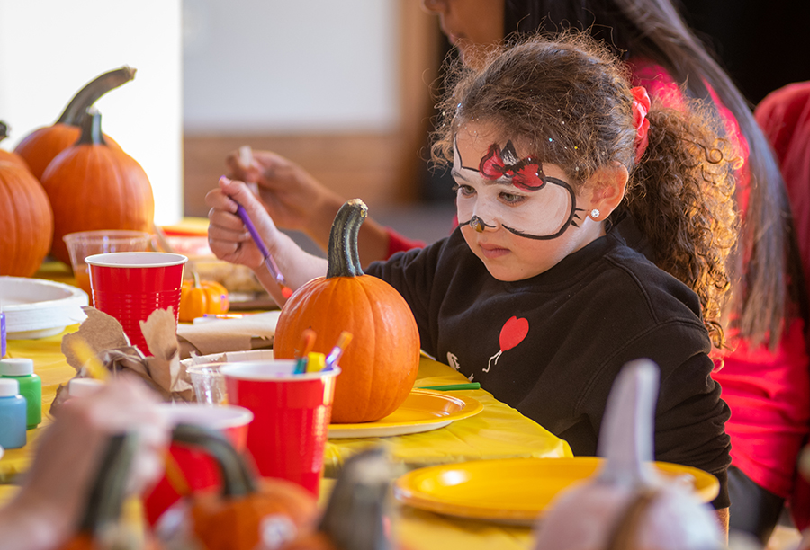 child painting pumpkin