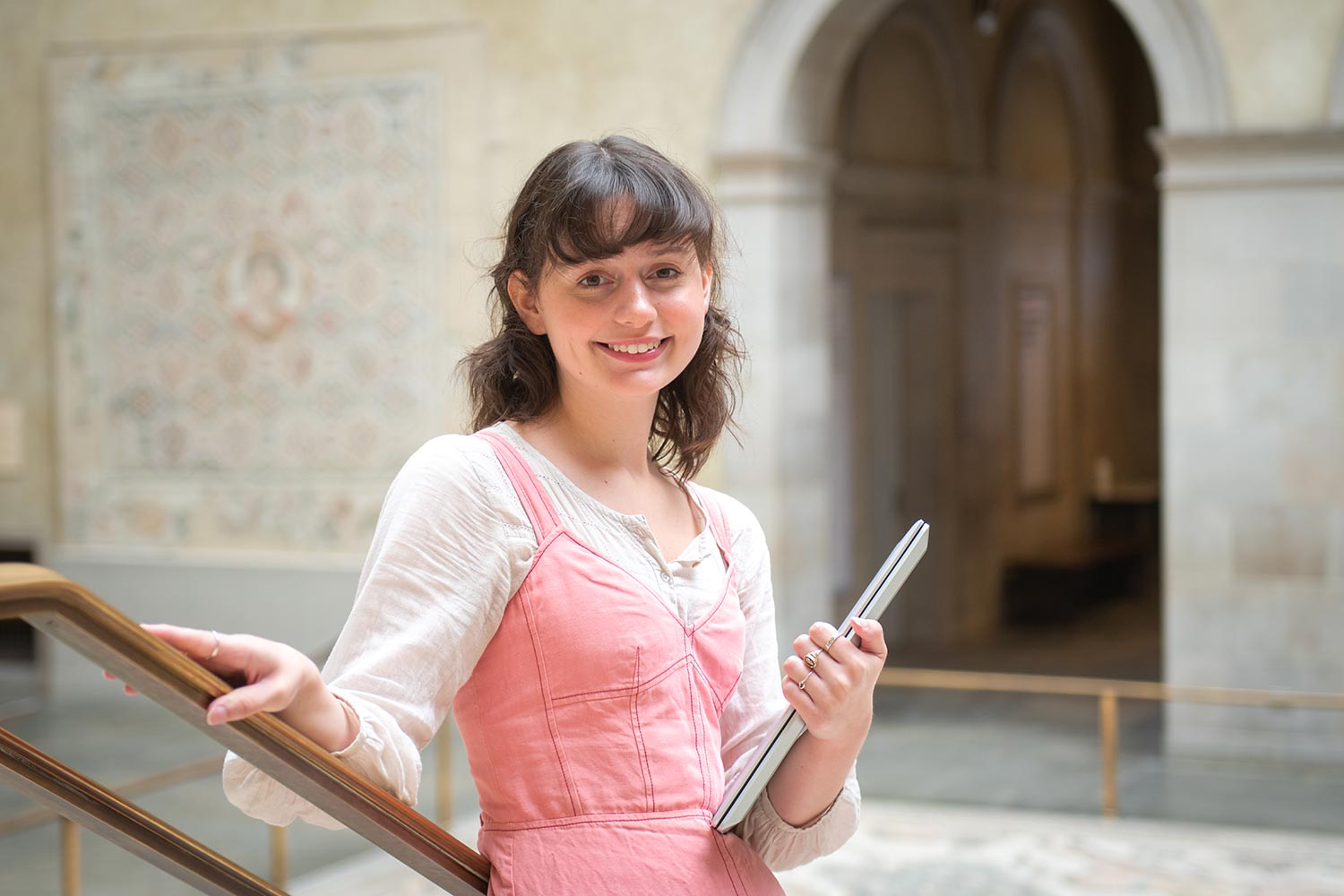 History of art major, Abbie Hart in the galleries of the Worcester Art Museum holding a notebook.
