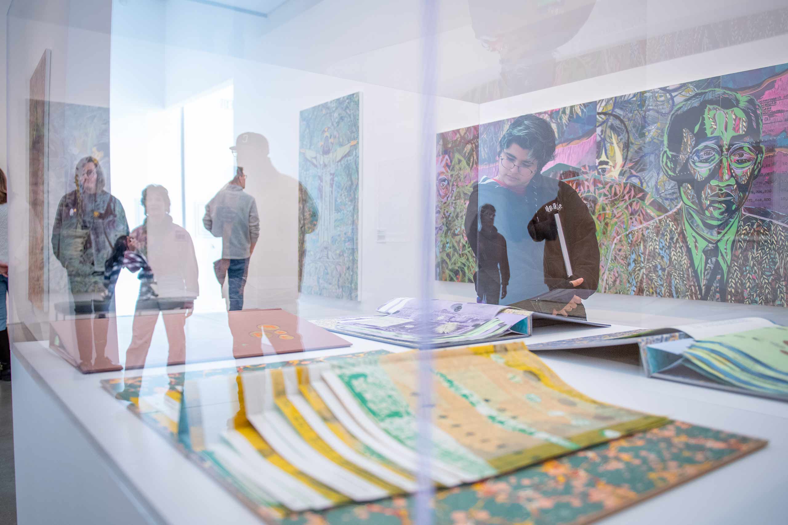 A student looks at art books inside a plexiglass box at the Institute for Contemporary Art, Boston.