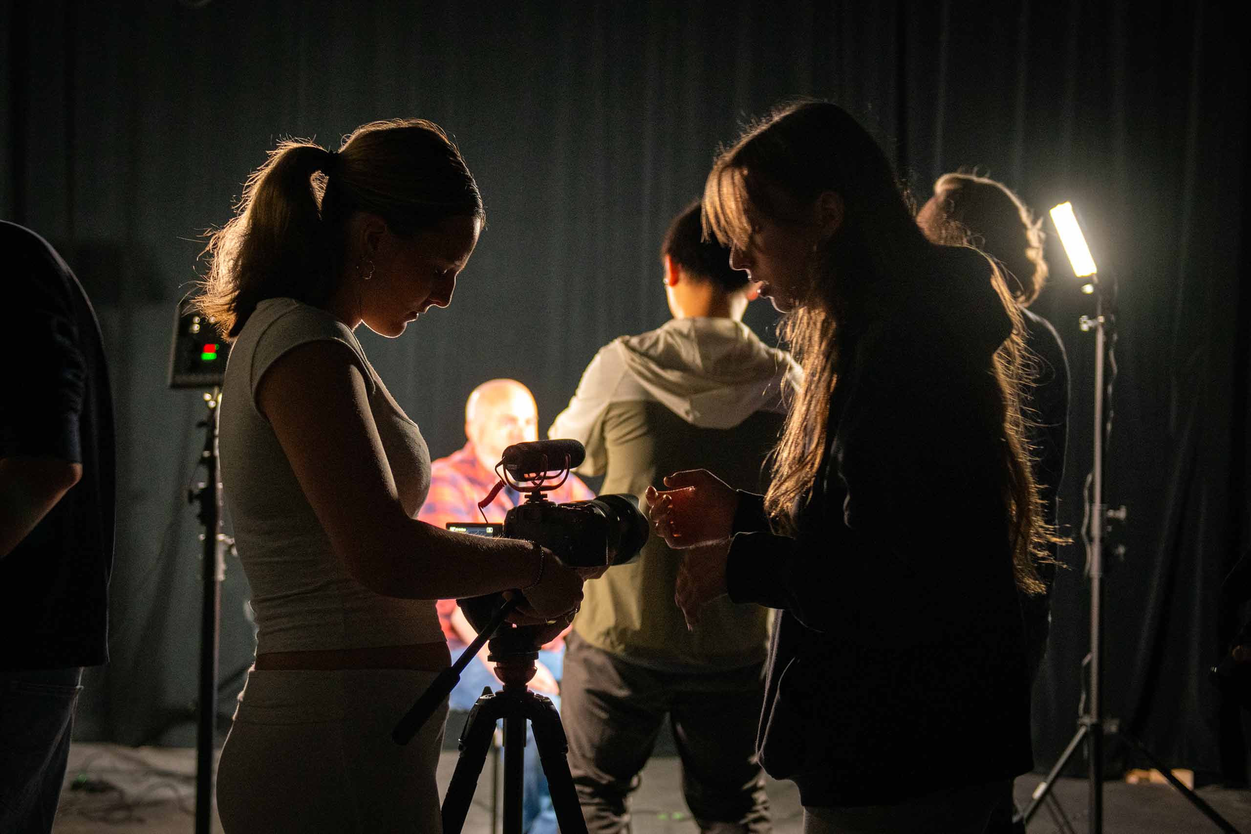 Students adjusting their camera settings during an Intro to Digital Filmmaking class.