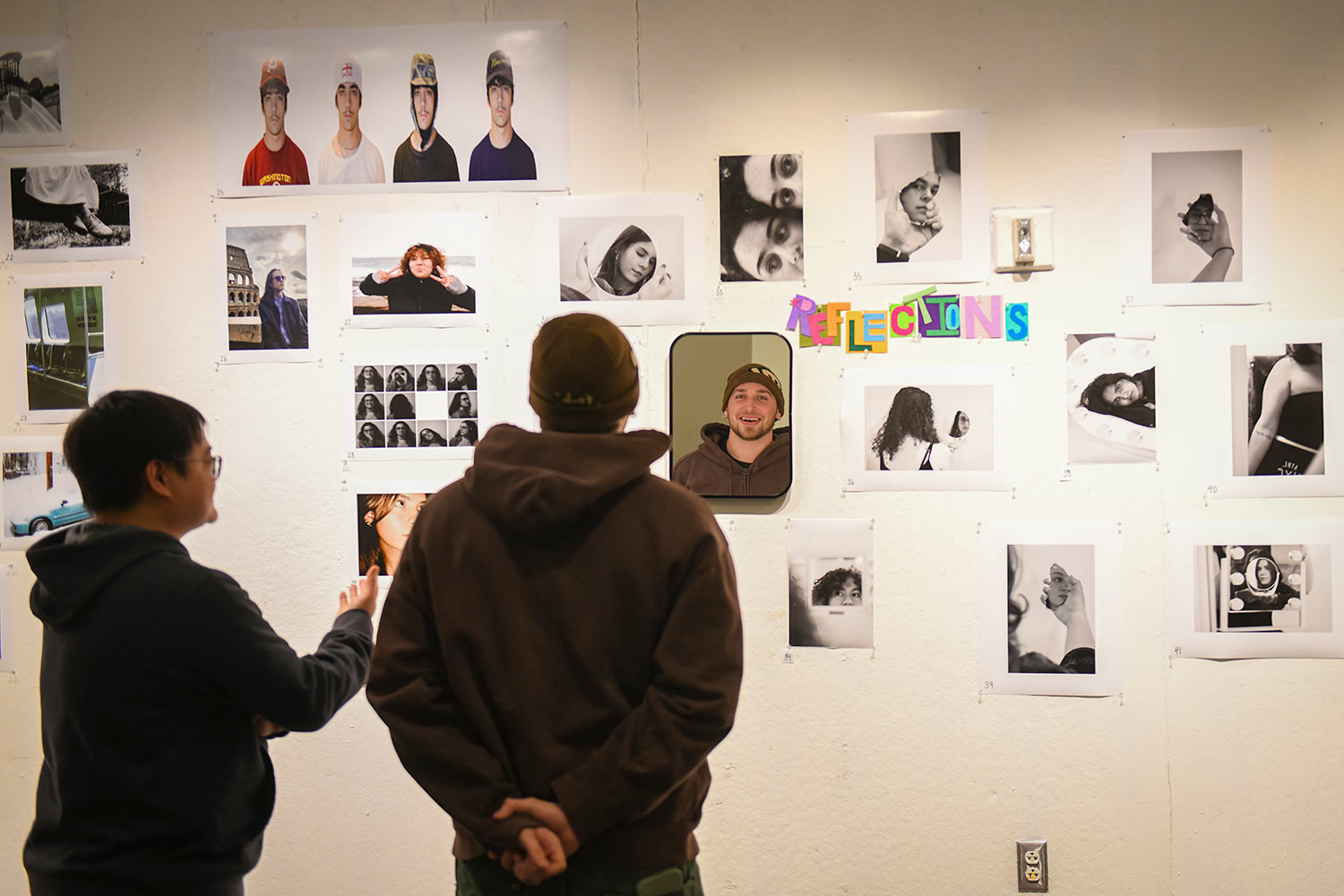 Visitors view photography in the student exhibit at the Train Center.