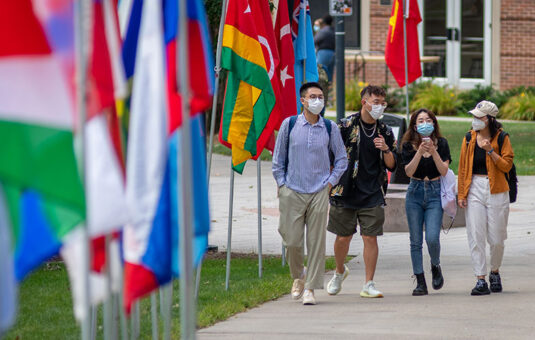 Students walking near flags