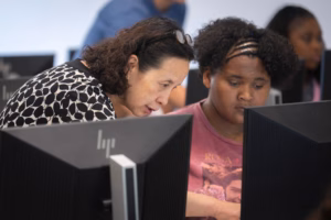 Li Han helping a middle school student at a computer