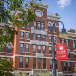 Jonas Clark Hall behind a lamppost and Clark University banner