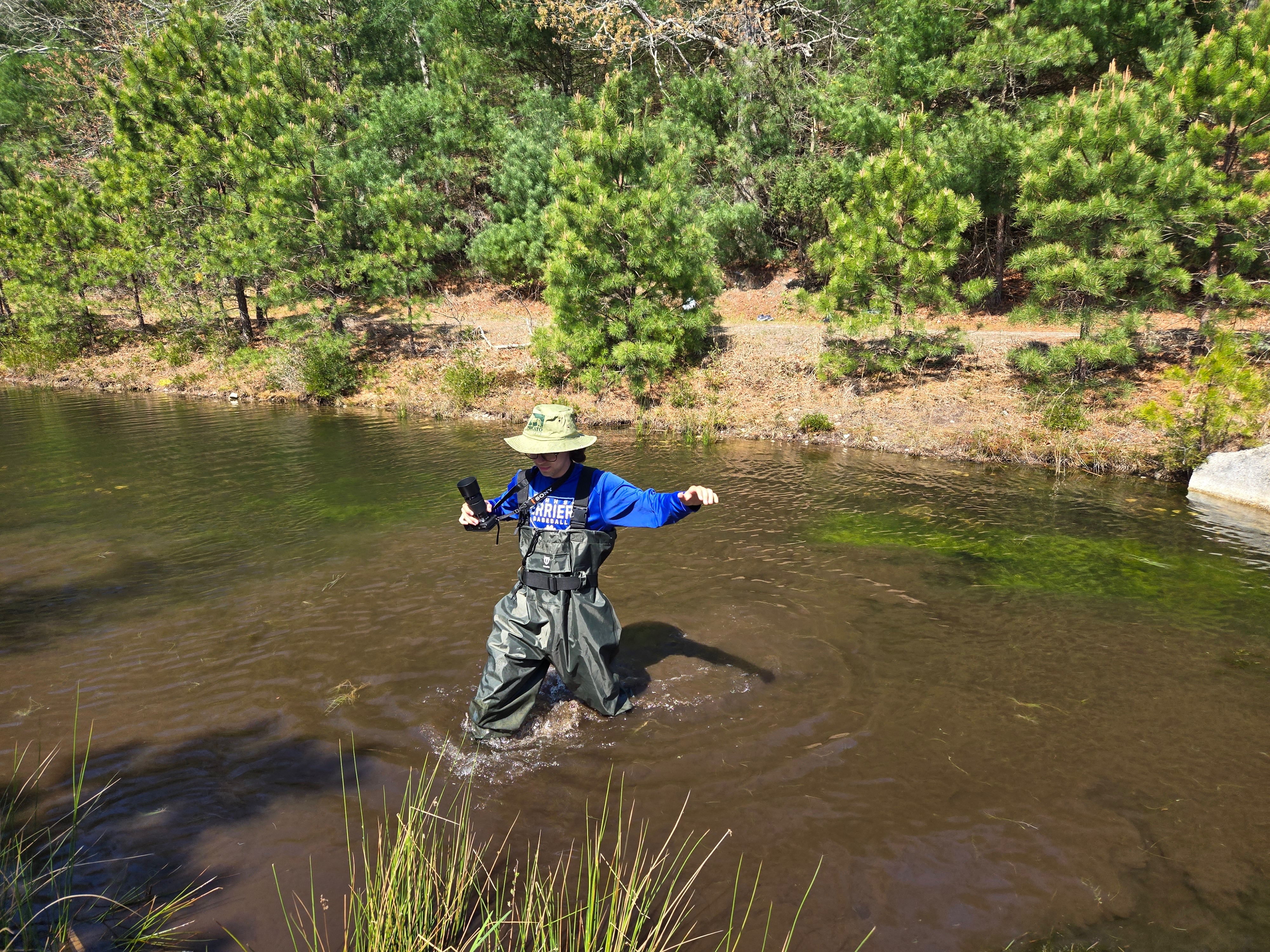 student wades through bog