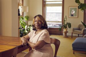 woman sits at table in house