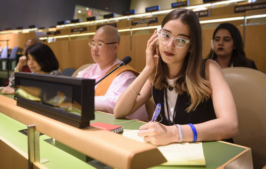 Female student listening to transcript with head set