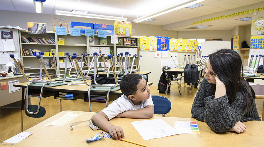 young k-6 student doing homework with Clark student