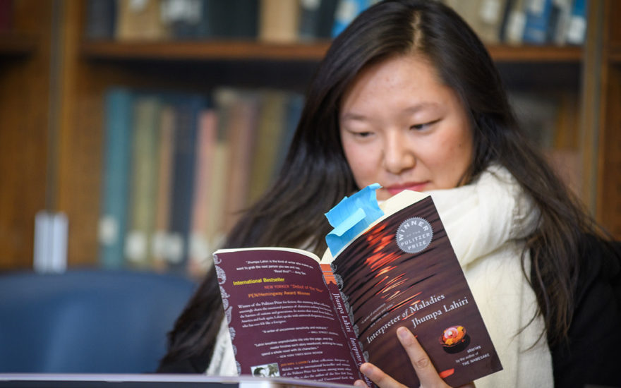 Student reading book in English class