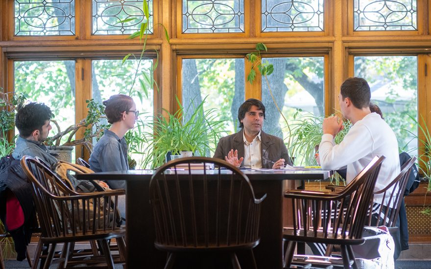 Students and professor talking at seminar table