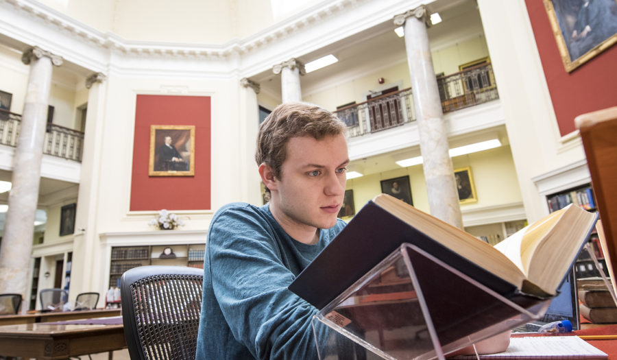 male student looking at book