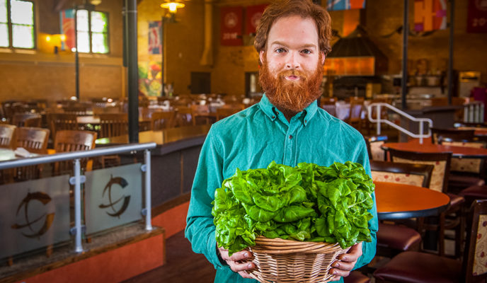 male holding basket of leafy greens