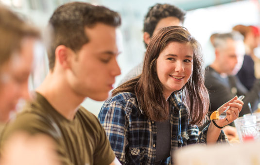 Students eating food at a restaurant counter