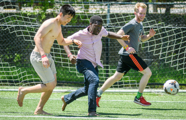 male students playing socce