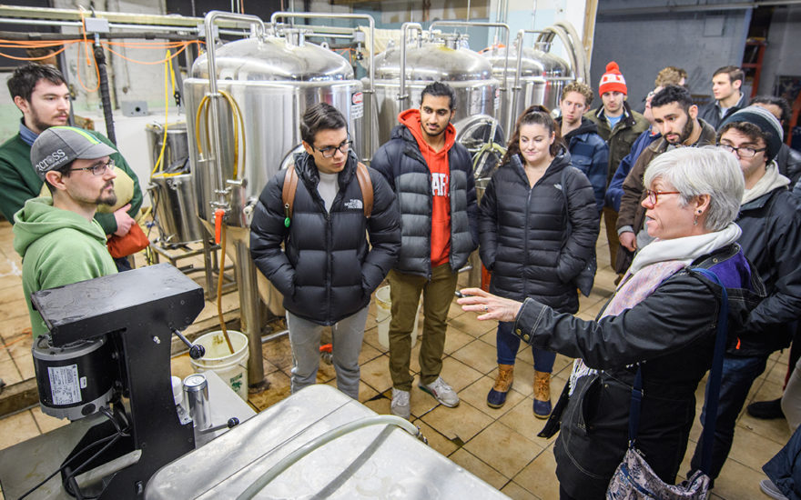 professor for economics major talking to students in beer factory