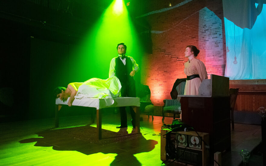 theatre scene on stage with man lying on table