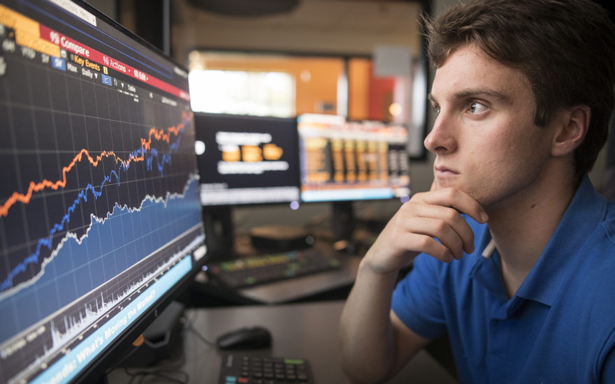 student looking at pc screen with graphs on