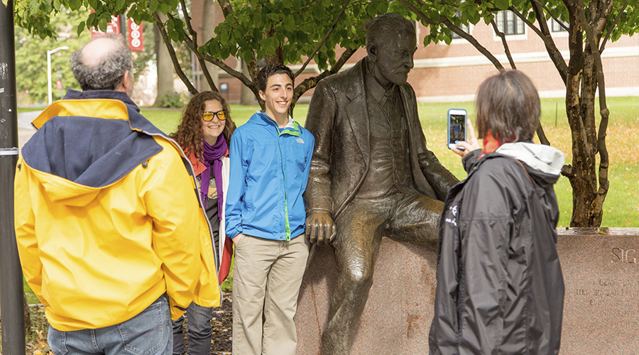 families posing with statue