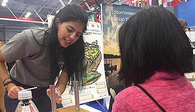 Student helping young child at physics fair