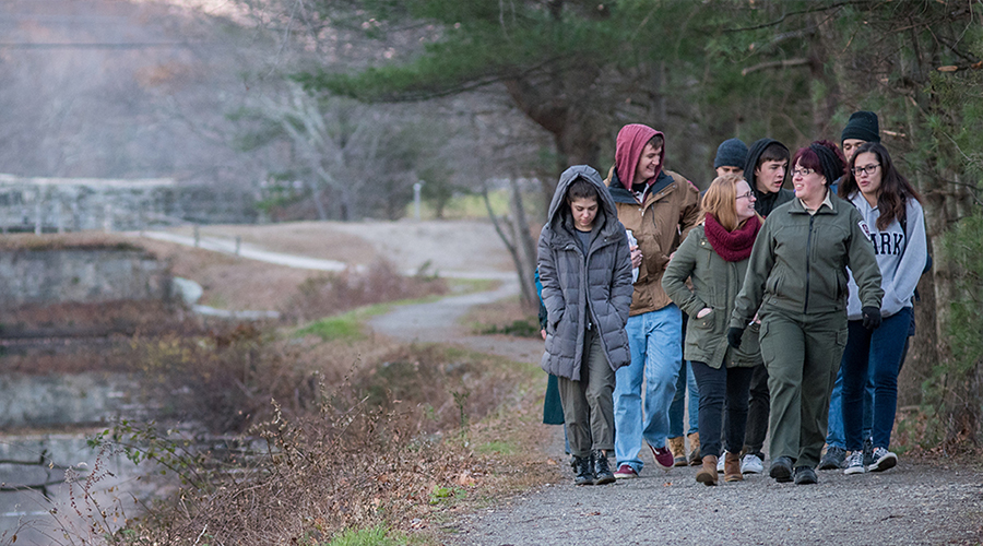 students walking down path near pond