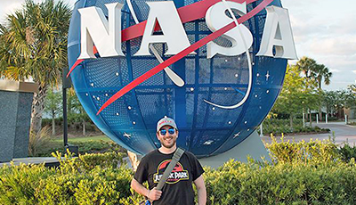 alum in front of nasa sign