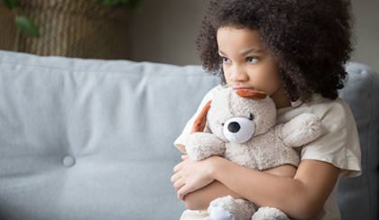 sad child hugging a teddy bear