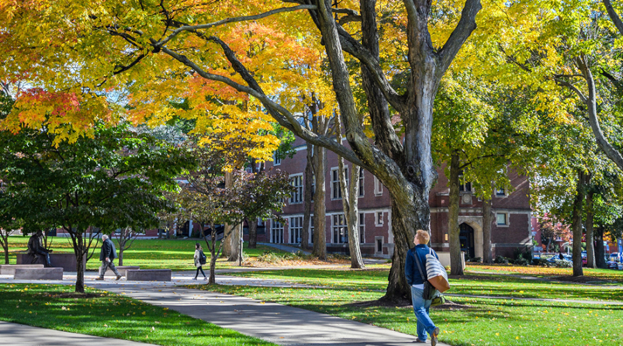 student walking on campus green