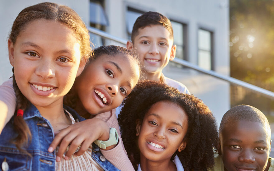 Group of children smiling on school steps