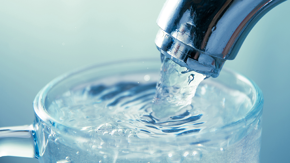 Water flowing from tap into glass