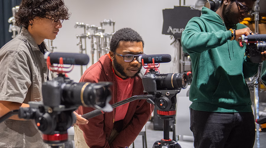 Students in film making class looking at cameras