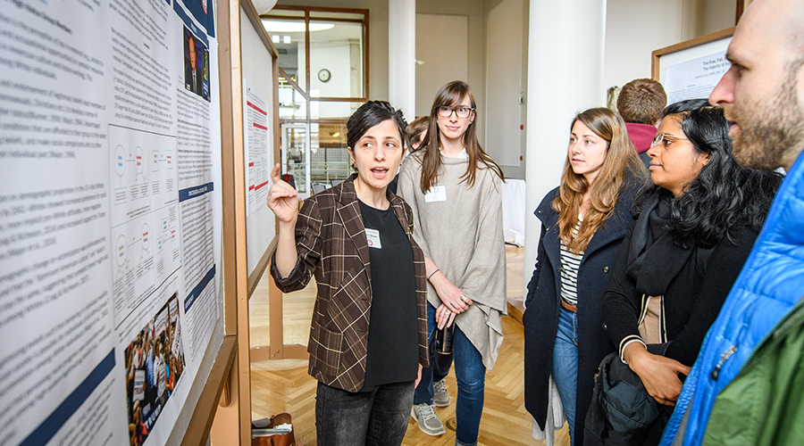 Grad student reviewing presentation board at the graduate multidisciplinary conference