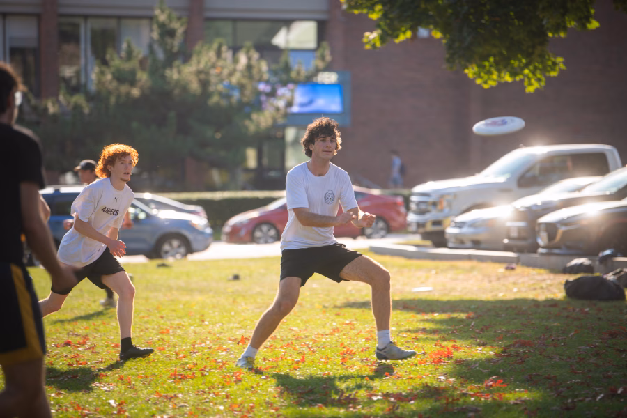 Students playing ultimate frisbee on campus