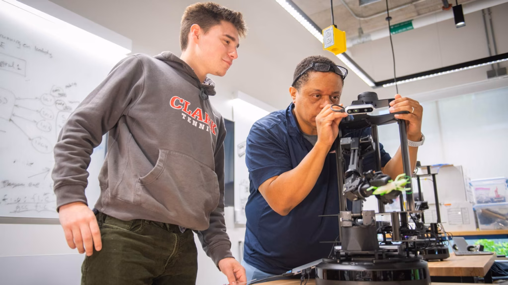 Professor Gary Holness works with a student on a robotics devices with applications for agriculture