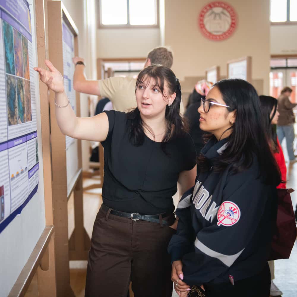 a student explains her poster at ClarkFEST