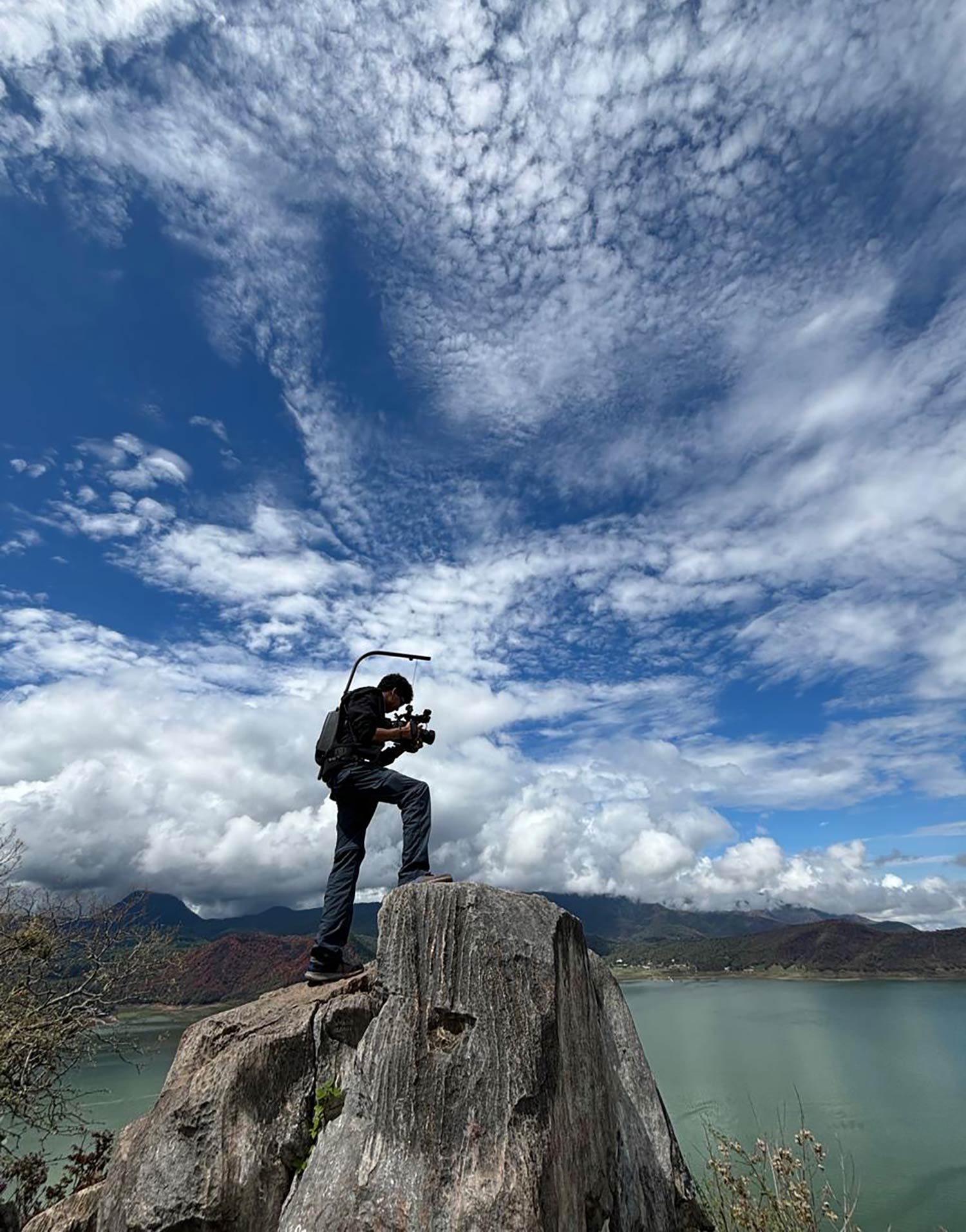 Aidan Hilaire ’26 filming Valle de Bravo reservoir from a rocky vantage point. Photo courtesy of Professor Tim Downs.