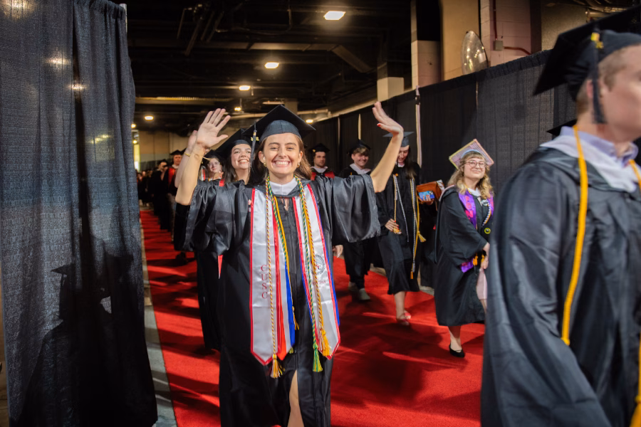 Student raising hands up at commencement cerermony