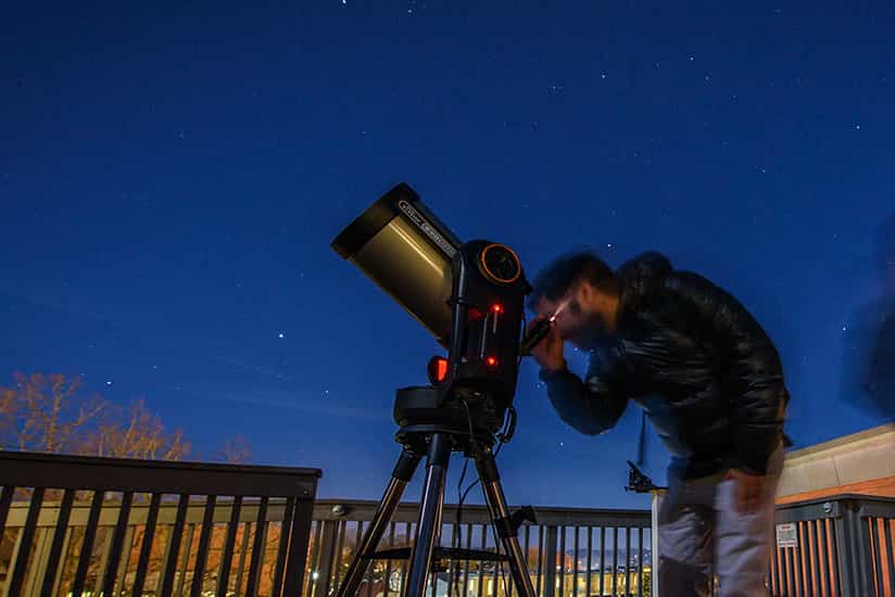 a student gazes through a telescope