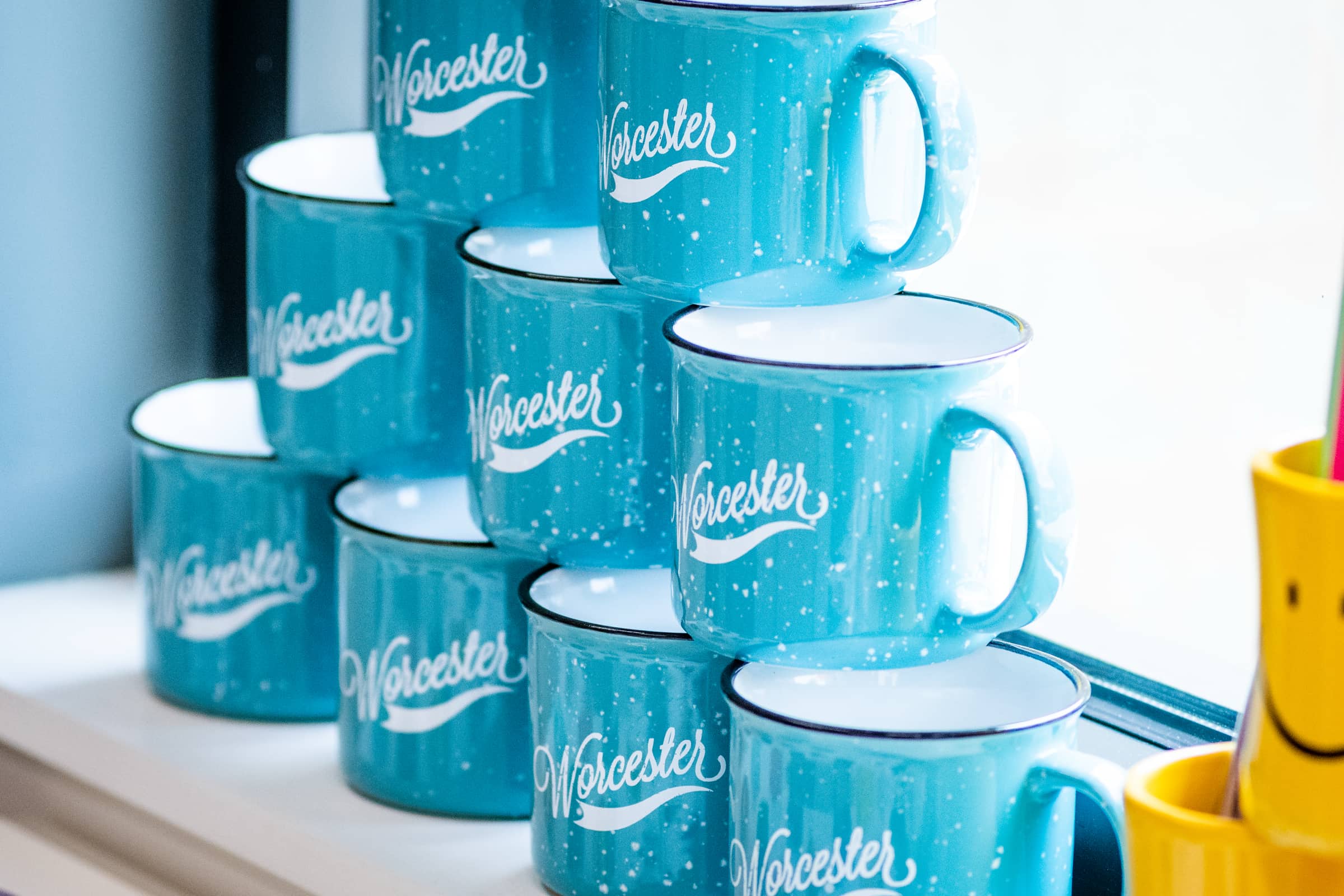 A stack of Worcester-branded mugs