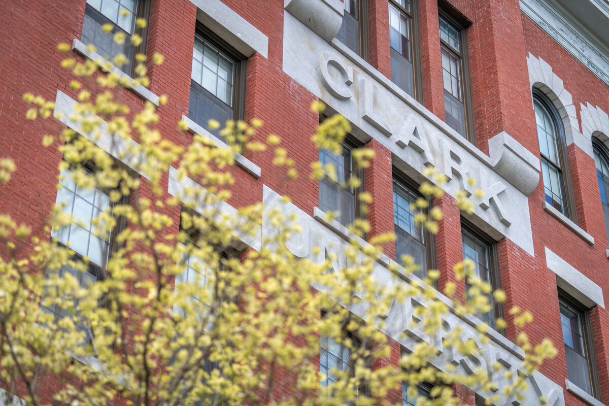 Facade of Jonas Hall with springtime blooming trees in the foreground.