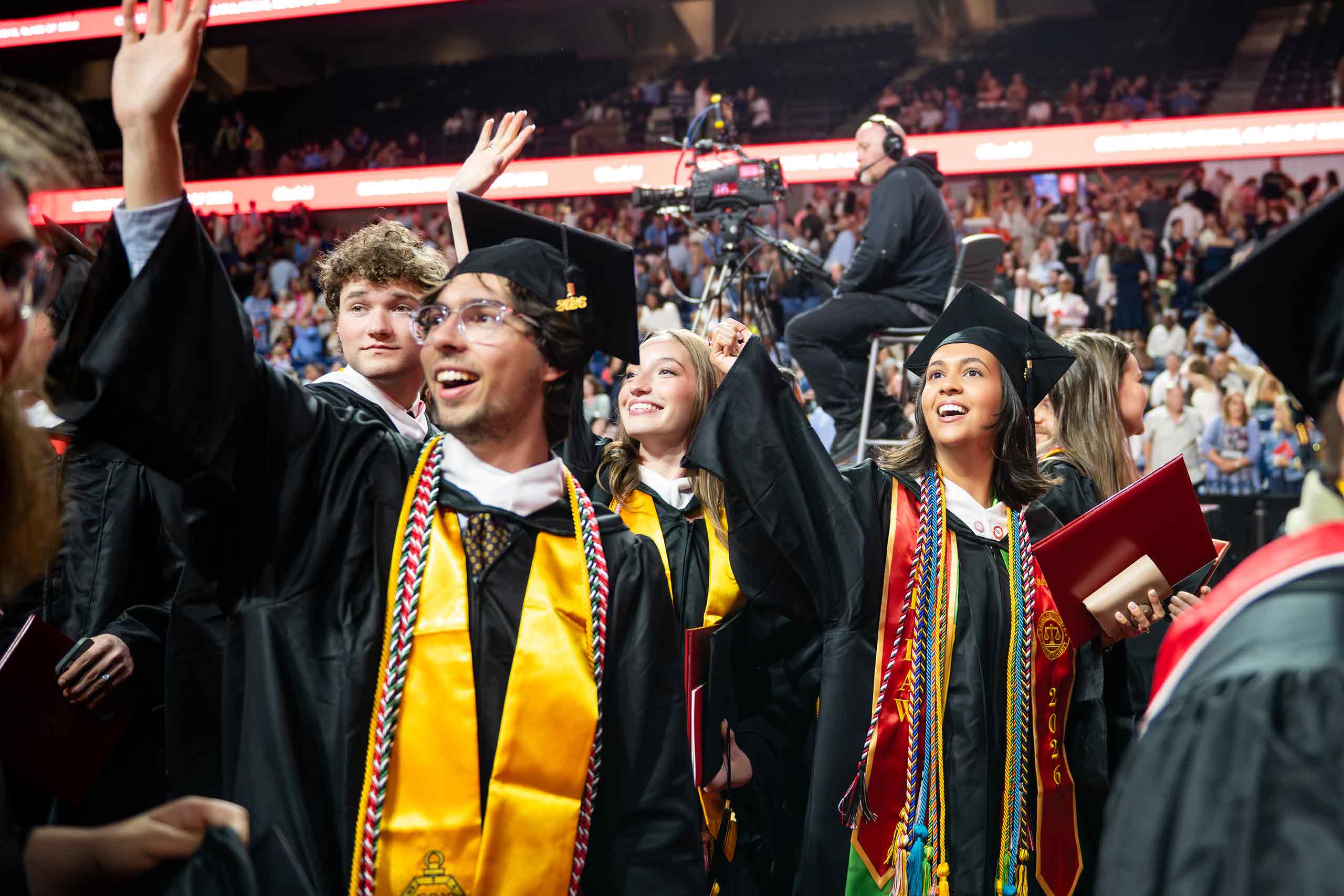 Students celebrate and wave during the undergraduate commencement ceremony, May 18, 2026.