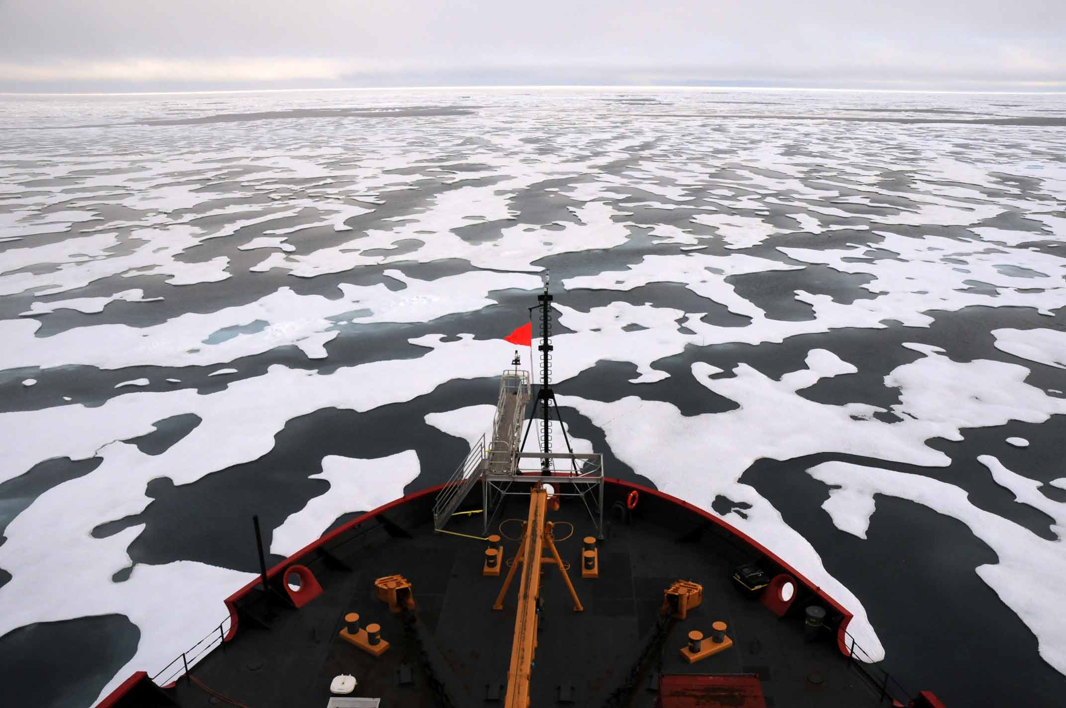 The bow of a research vessels ventures into a field of ice flows in the Arctic.