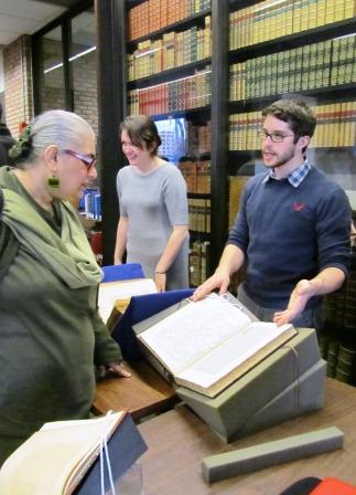 professor looing over large book