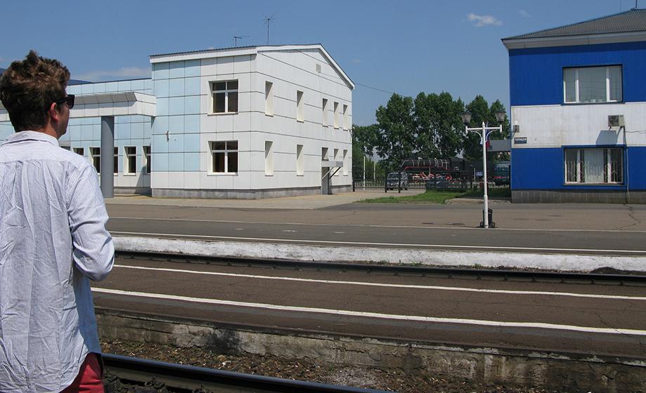 Aviv Hilbig-Bokaer looks across train tracks at a stop in Novosibirsk, Russia.